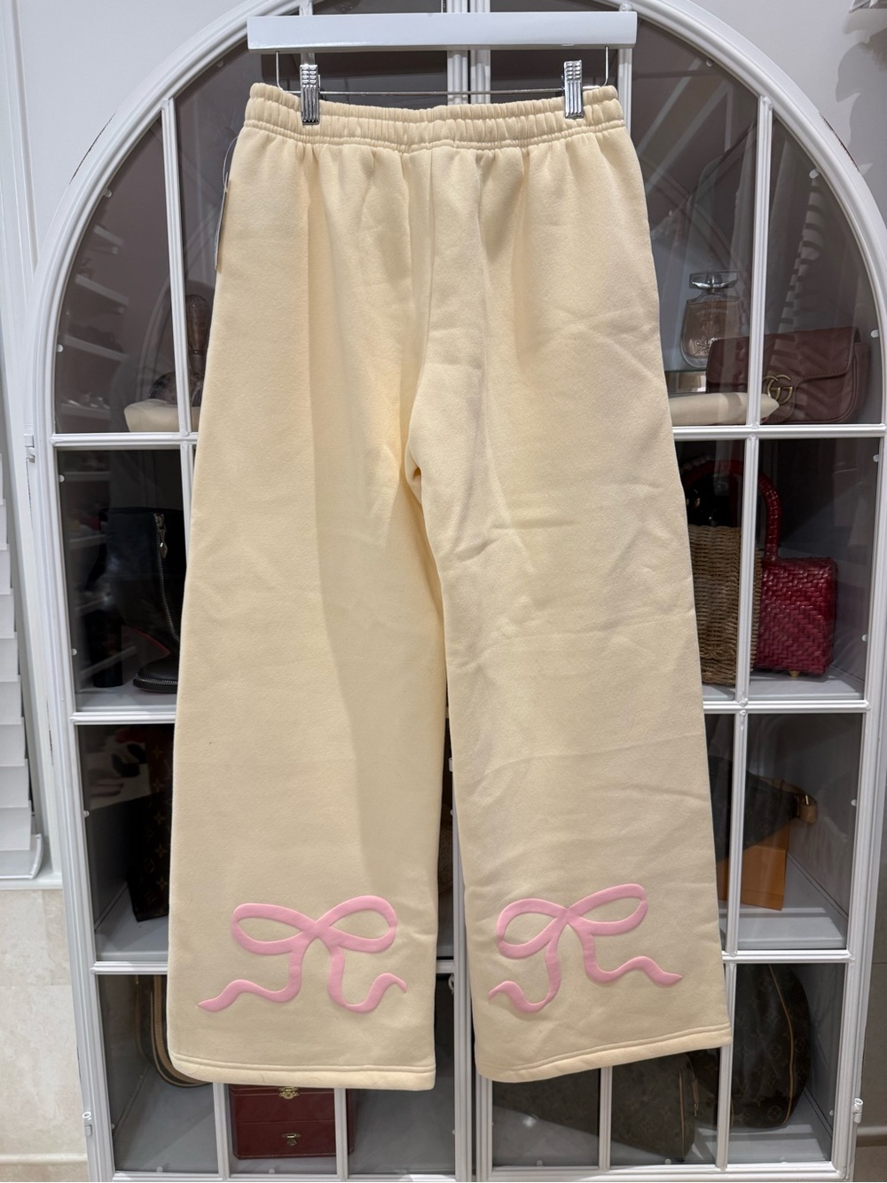 Edikted Cream/Light YellowTrack Pants with Pink Bow Detail on back of pants.